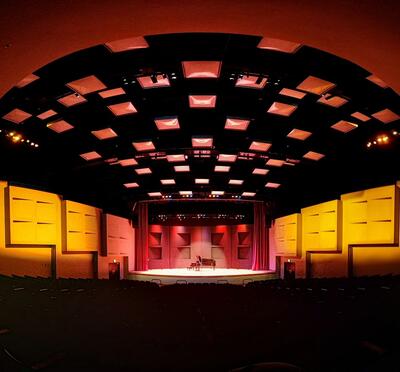 Austin Auditorium stage from a far viewpoint with red to yellow lighting